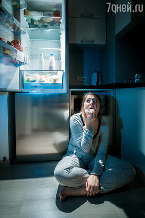 голодная женщина ночью у холодильника